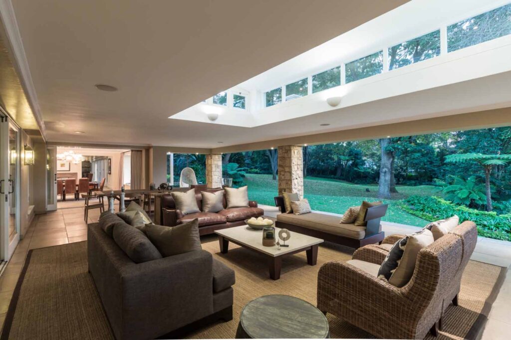 This Bryanston mansion on the market for R45m boasts true indoor-outdoor living with this covered lounge and two swimming pools.