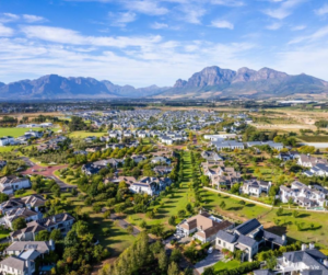 Aerial view of a landscaped residential estate with mountains in the background.
