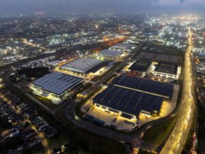 Aerial view of a large logistics and industrial warehouse park at night supporting Fortress Real Estate Growth.