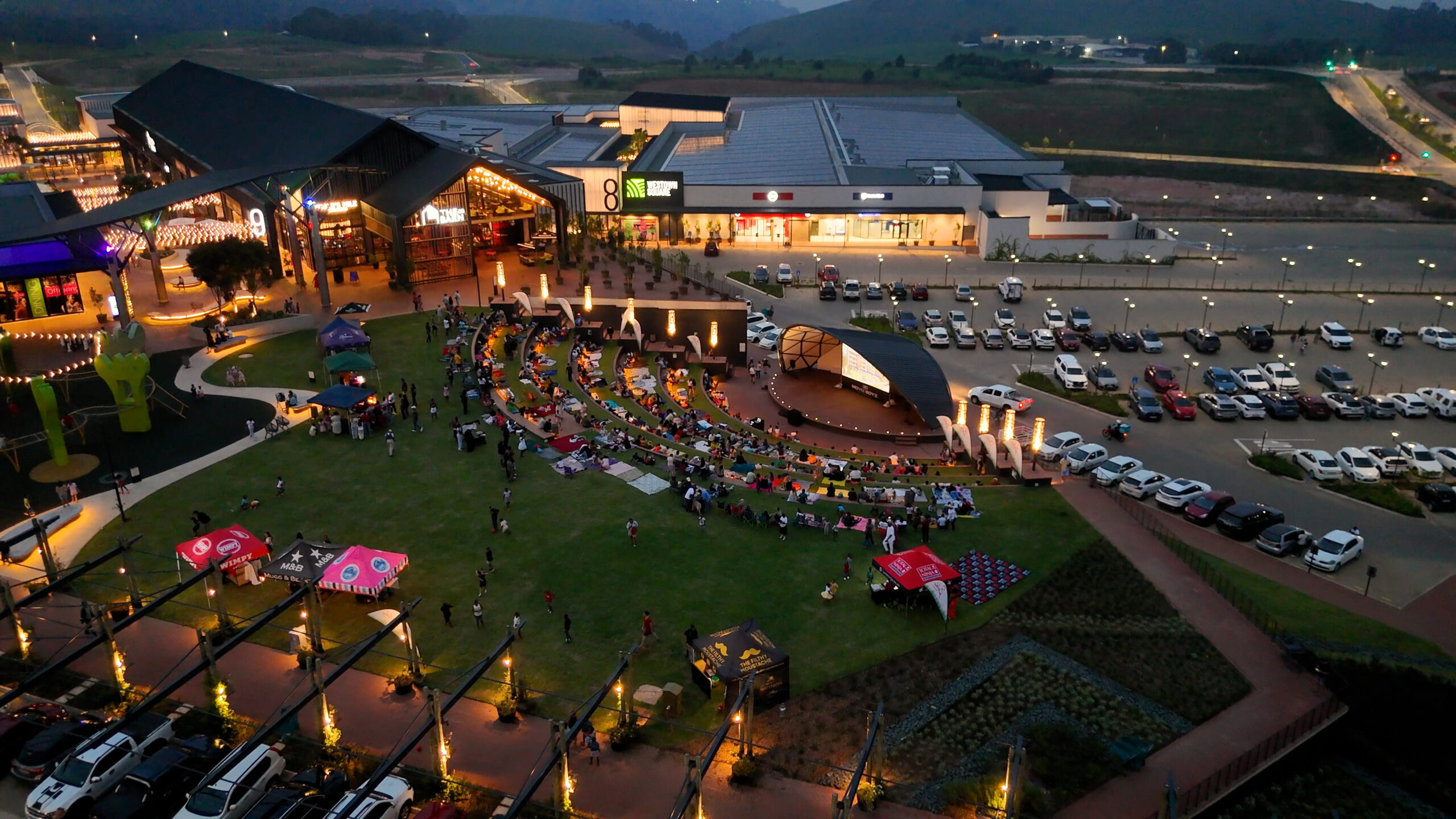 Aerial view of Westown Square event lawn with live entertainment and visitors