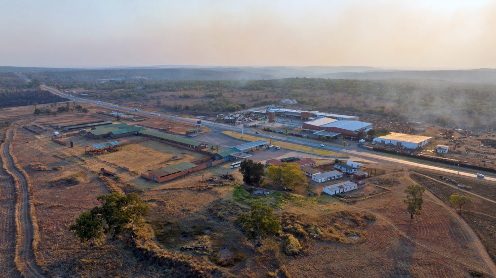 Aerial view of farmland and bush along the corridor, with the road running through it and the retail node visible in the middle distance.