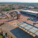 Aerial view of the Wadrif node showing long warehouse roofs, a loading yard with trucks and the retail frontage facing the R573.
